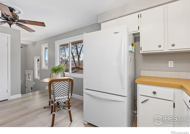 kitchen with ceiling fan, light wood-style flooring, freestanding refrigerator, light countertops, and white cabinetry