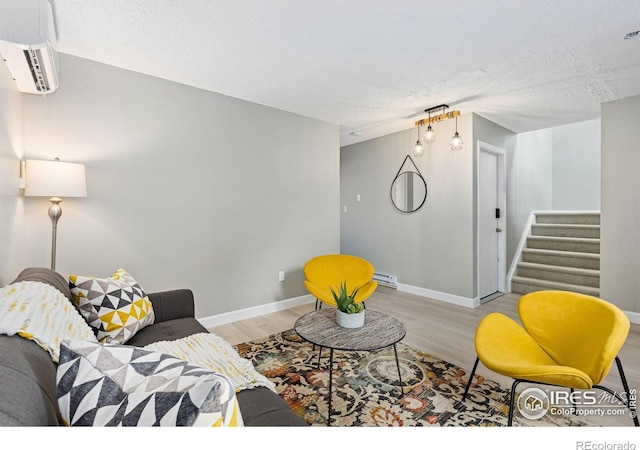 living room featuring a baseboard radiator, stairway, baseboards, and wood finished floors