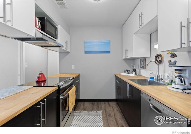 kitchen featuring electric range, a sink, visible vents, wood counters, and stainless steel dishwasher