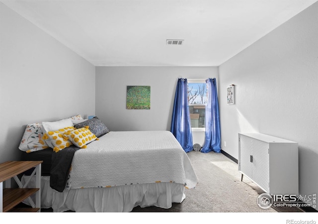 carpeted bedroom with visible vents and baseboards