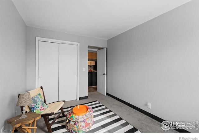 carpeted bedroom featuring a closet and baseboards