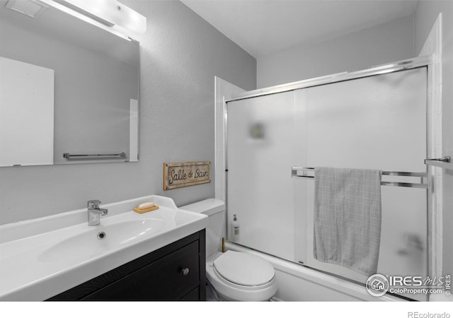 full bath with visible vents, toilet, vanity, and combined bath / shower with glass door