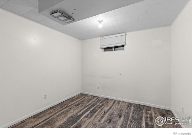 spare room featuring baseboards and wood finished floors