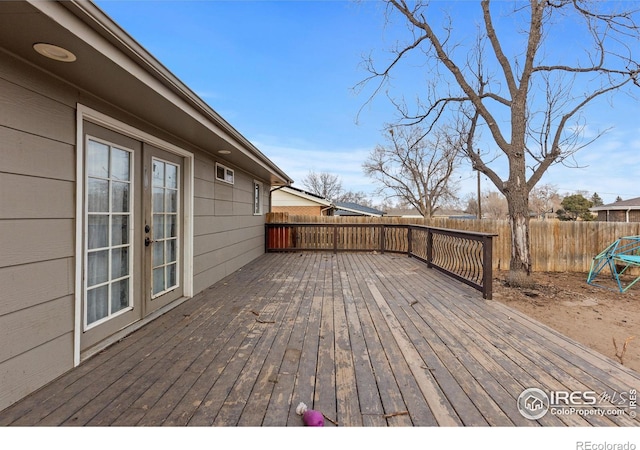 wooden deck with a fenced backyard and french doors