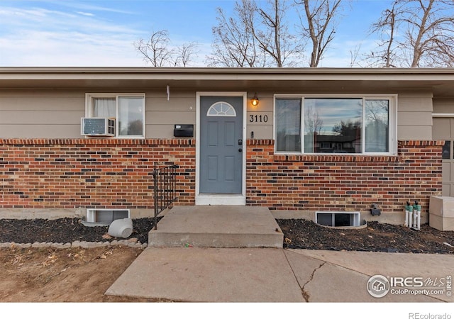 entrance to property featuring brick siding