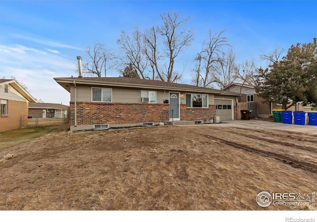 view of front of house featuring concrete driveway, brick siding, an attached garage, and fence