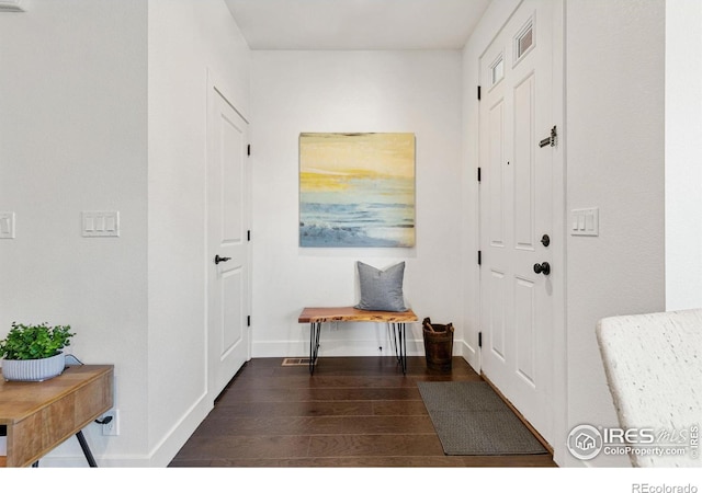 interior space featuring visible vents, dark wood finished floors, and baseboards