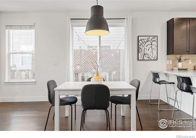 dining space featuring baseboards and dark wood finished floors