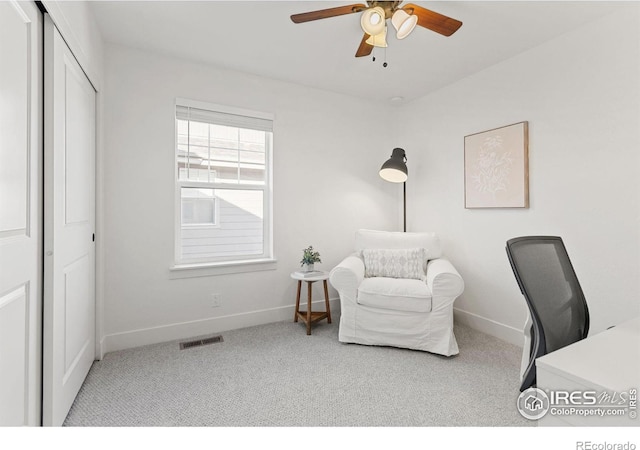 carpeted office space with baseboards, visible vents, and a ceiling fan