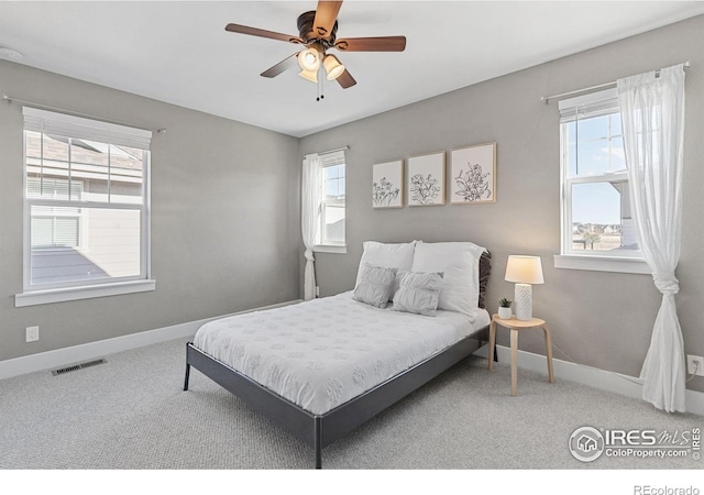 bedroom featuring multiple windows, carpet, visible vents, and baseboards