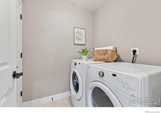 clothes washing area featuring laundry area, baseboards, and separate washer and dryer