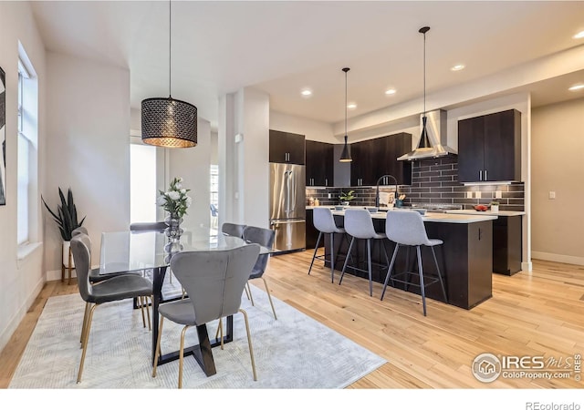 dining area with light wood-type flooring, baseboards, and recessed lighting