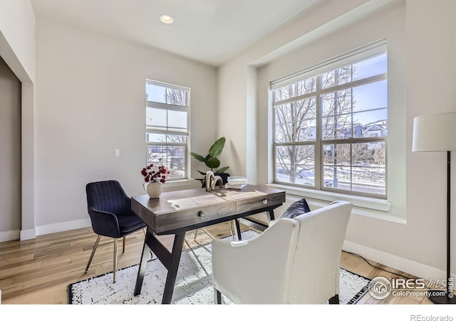 office space featuring light wood-style floors, a wealth of natural light, and baseboards