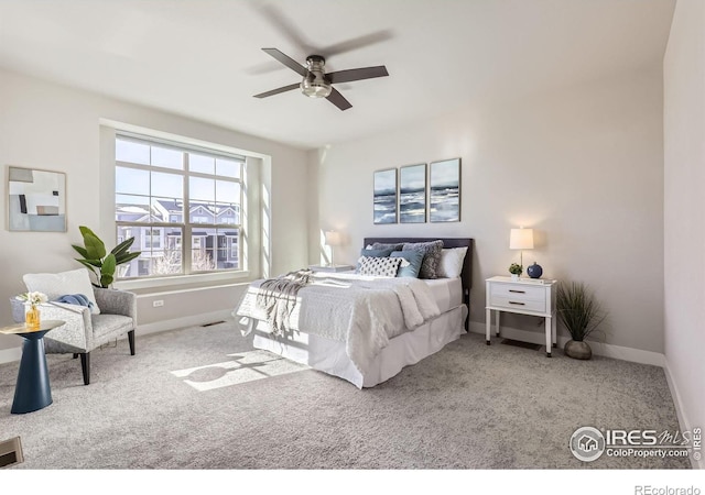 carpeted bedroom featuring a ceiling fan, visible vents, and baseboards