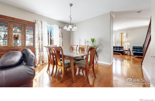 7145 Brittany Dr, Fort Collins, CO 80525 - dining room with a chandelier, wood finished floors, and baseboards