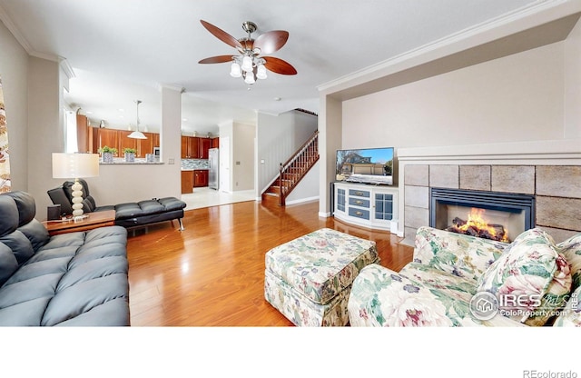 7145 Brittany Dr, Fort Collins, CO 80525 - living area with crown molding, ceiling fan, light wood-style floors, stairway, and baseboards