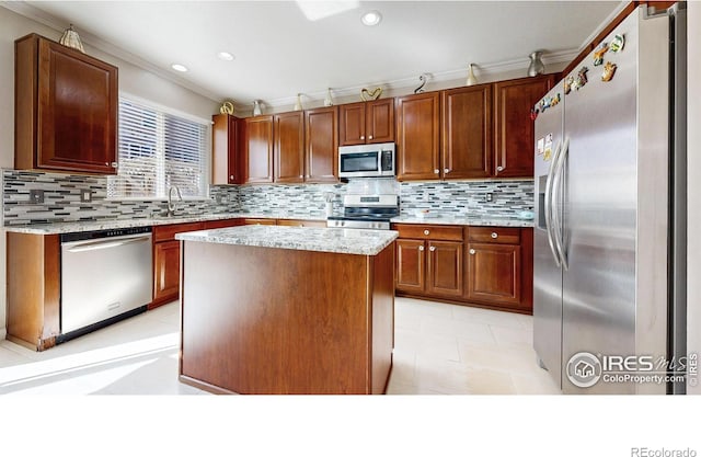 7145 Brittany Dr, Fort Collins, CO 80525 - kitchen with stainless steel appliances, crown molding, decorative backsplash, recessed lighting, and a kitchen island