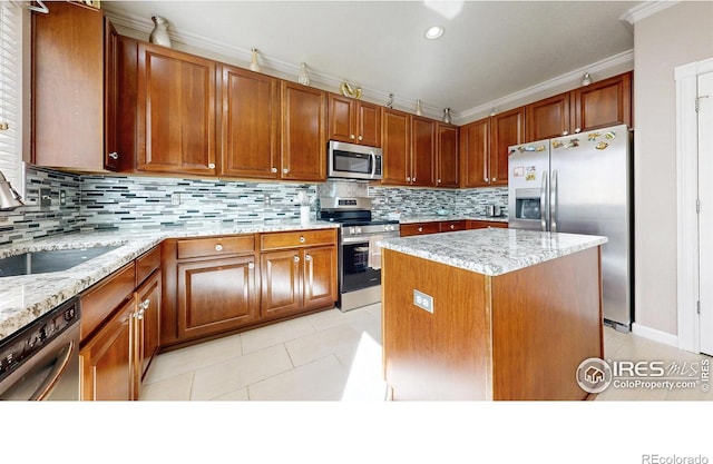7145 Brittany Dr, Fort Collins, CO 80525 - kitchen featuring stainless steel appliances, ornamental molding, a sink, a center island, and light tile patterned floors