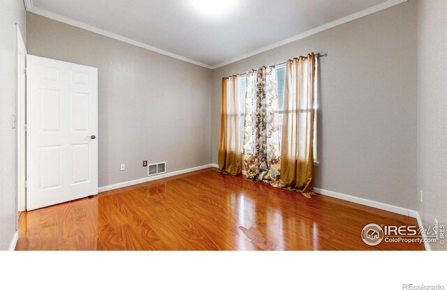 7145 Brittany Dr, Fort Collins, CO 80525 - empty room with wood finished floors, crown molding, and baseboards