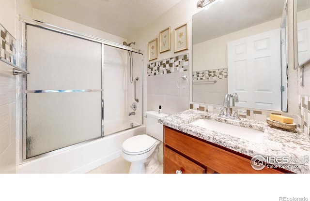 7145 Brittany Dr, Fort Collins, CO 80525 - full bathroom featuring tile walls, toilet, vanity, and enclosed tub / shower combo