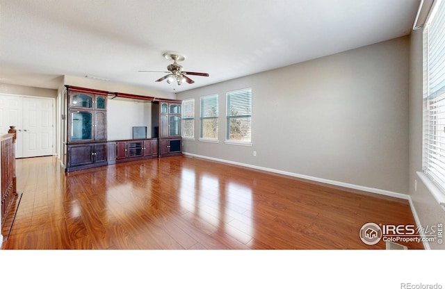 7145 Brittany Dr, Fort Collins, CO 80525 - unfurnished living room featuring baseboards, wood finished floors, and a ceiling fan