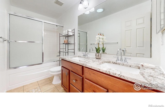 7145 Brittany Dr, Fort Collins, CO 80525 - full bathroom featuring tile patterned flooring, toilet, double vanity, and bath / shower combo with glass door