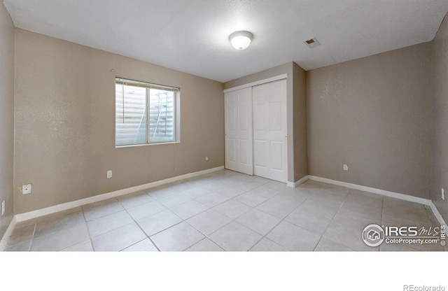 7145 Brittany Dr, Fort Collins, CO 80525 - unfurnished bedroom with light tile patterned flooring, baseboards, and a closet