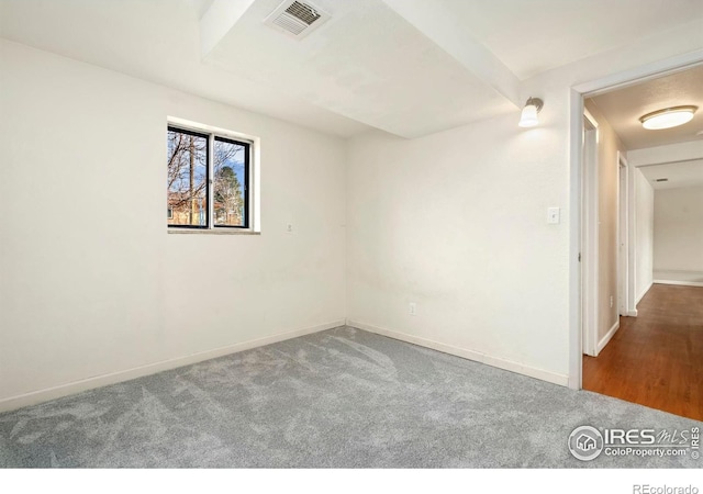 unfurnished room with carpet, visible vents, and baseboards