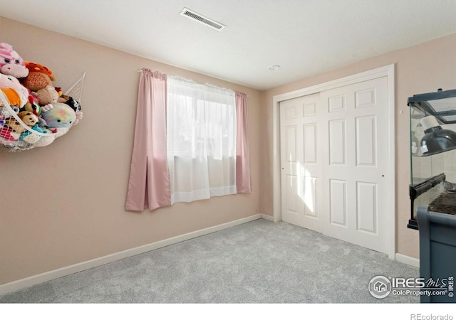 unfurnished bedroom featuring carpet, a closet, visible vents, and baseboards