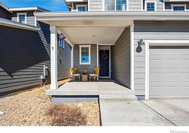 view of exterior entry featuring a garage and covered porch