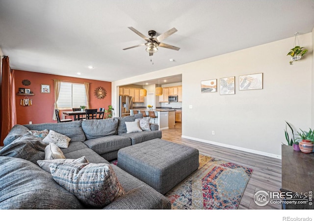 living area featuring light wood-style floors, recessed lighting, ceiling fan, and baseboards