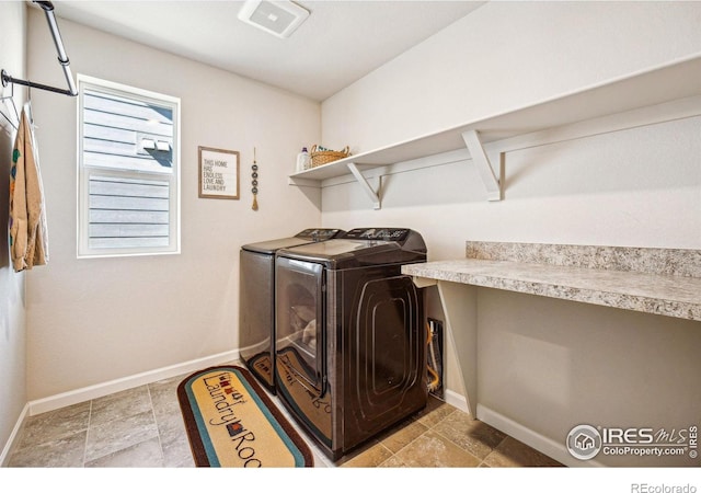 washroom featuring washing machine and dryer, laundry area, and baseboards