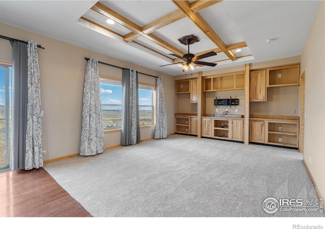 living area featuring ceiling fan, light carpet, coffered ceiling, baseboards, and beamed ceiling