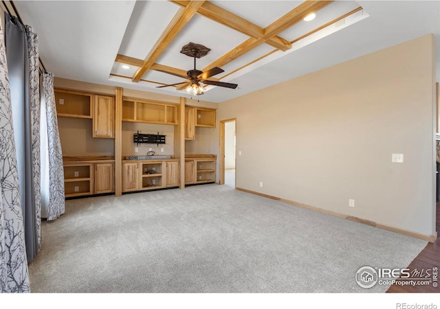 unfurnished living room featuring baseboards, coffered ceiling, light colored carpet, ceiling fan, and beam ceiling