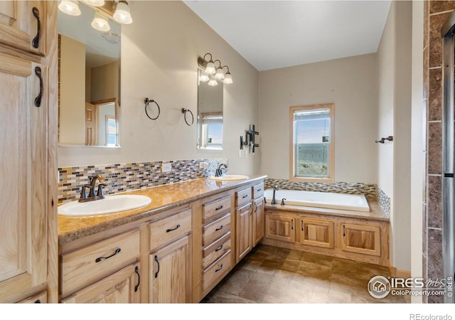 bathroom featuring tasteful backsplash, a sink, and a healthy amount of sunlight