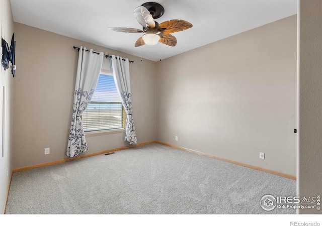 carpeted empty room with a ceiling fan, visible vents, and baseboards