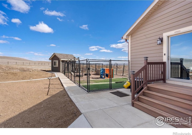 exterior space featuring a storage shed, an outdoor structure, fence, and a gate