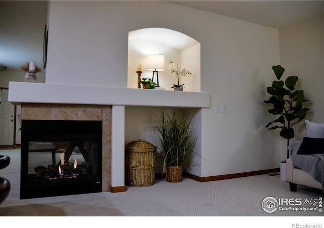 interior space featuring carpet, baseboards, and a tile fireplace