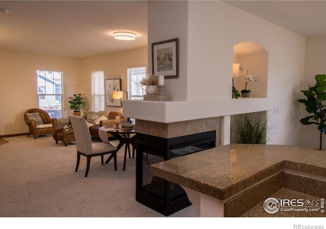 dining area with carpet and a tile fireplace