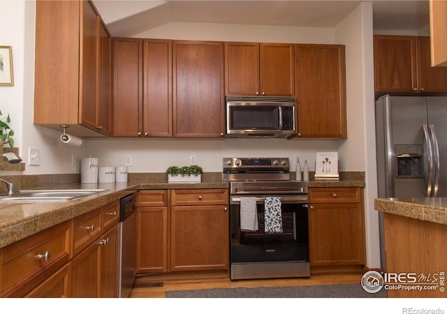 kitchen featuring tile countertops, brown cabinets, and stainless steel appliances