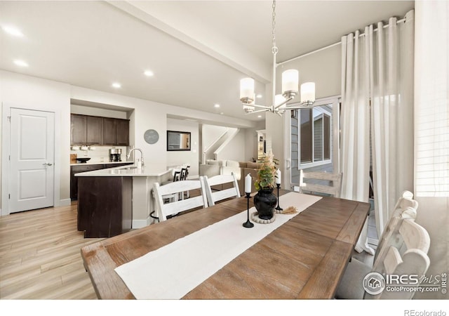 dining room featuring a chandelier, recessed lighting, beamed ceiling, and light wood-style flooring