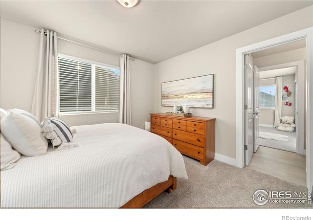 bedroom featuring baseboards and light colored carpet