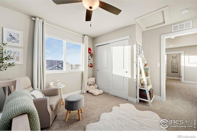 interior space with attic access, baseboards, visible vents, a ceiling fan, and carpet floors