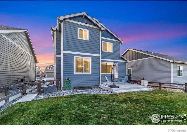 rear view of property with a patio, a yard, and fence