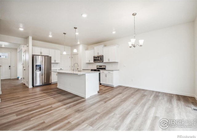 kitchen with light wood-style flooring, a notable chandelier, white cabinets, hanging light fixtures, and appliances with stainless steel finishes