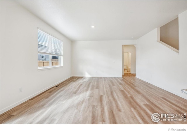 empty room featuring light wood finished floors and baseboards