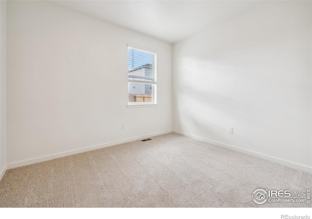 carpeted empty room featuring baseboards and visible vents