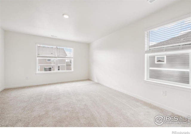 unfurnished room featuring carpet and baseboards