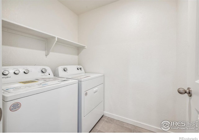 laundry room with laundry area, independent washer and dryer, light tile patterned flooring, and baseboards