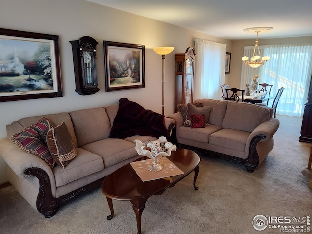 carpeted living room featuring a chandelier